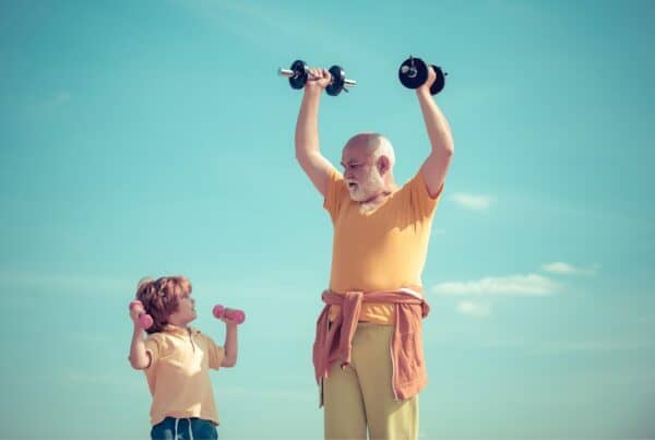Senior man with gray hair lifting dumbbells outdoors, fitness and confidence.