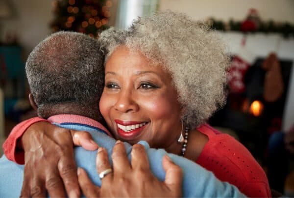 Happy senior woman with gray hair embracing a friend, celebrating confidence and style.