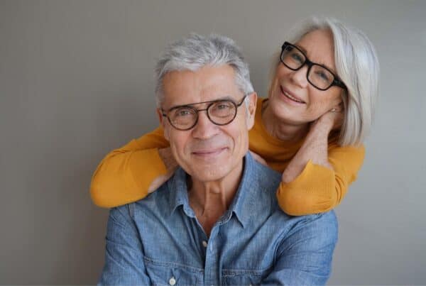 Happy senior couple with gray hair embracing, promoting confidence in gray hair.