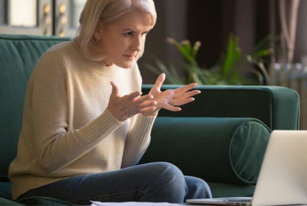 Confident senior woman with gray hair using a laptop at home.
