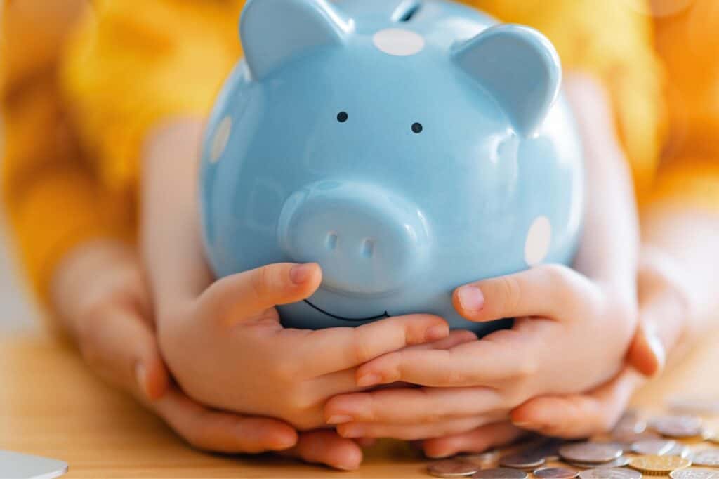 Blue piggy bank held by hands, symbolizing savings and confidence.