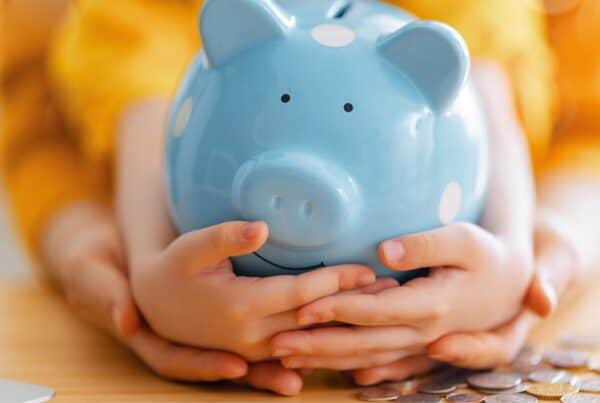 Blue piggy bank held by hands, symbolizing savings and confidence.