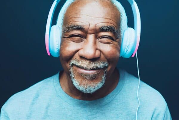 Happy senior man with gray hair wearing headphones, embracing aging and style.