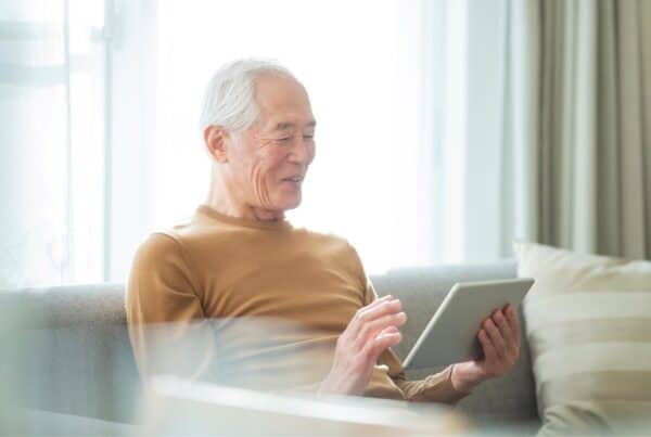 Senior woman with gray hair using a tablet at home.