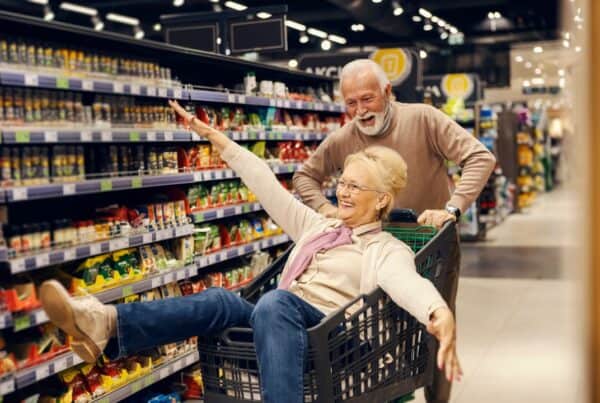 Older seniors enjoying grocery shopping with a smile, highlighting confidence and independence.