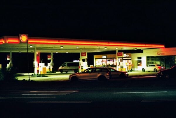 Gas station at night with Shell signage and parked vehicles, highlighting fuel station safety.