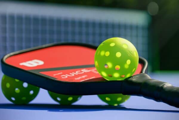 Pickleball paddle and balls on a court, perfect for senior players.